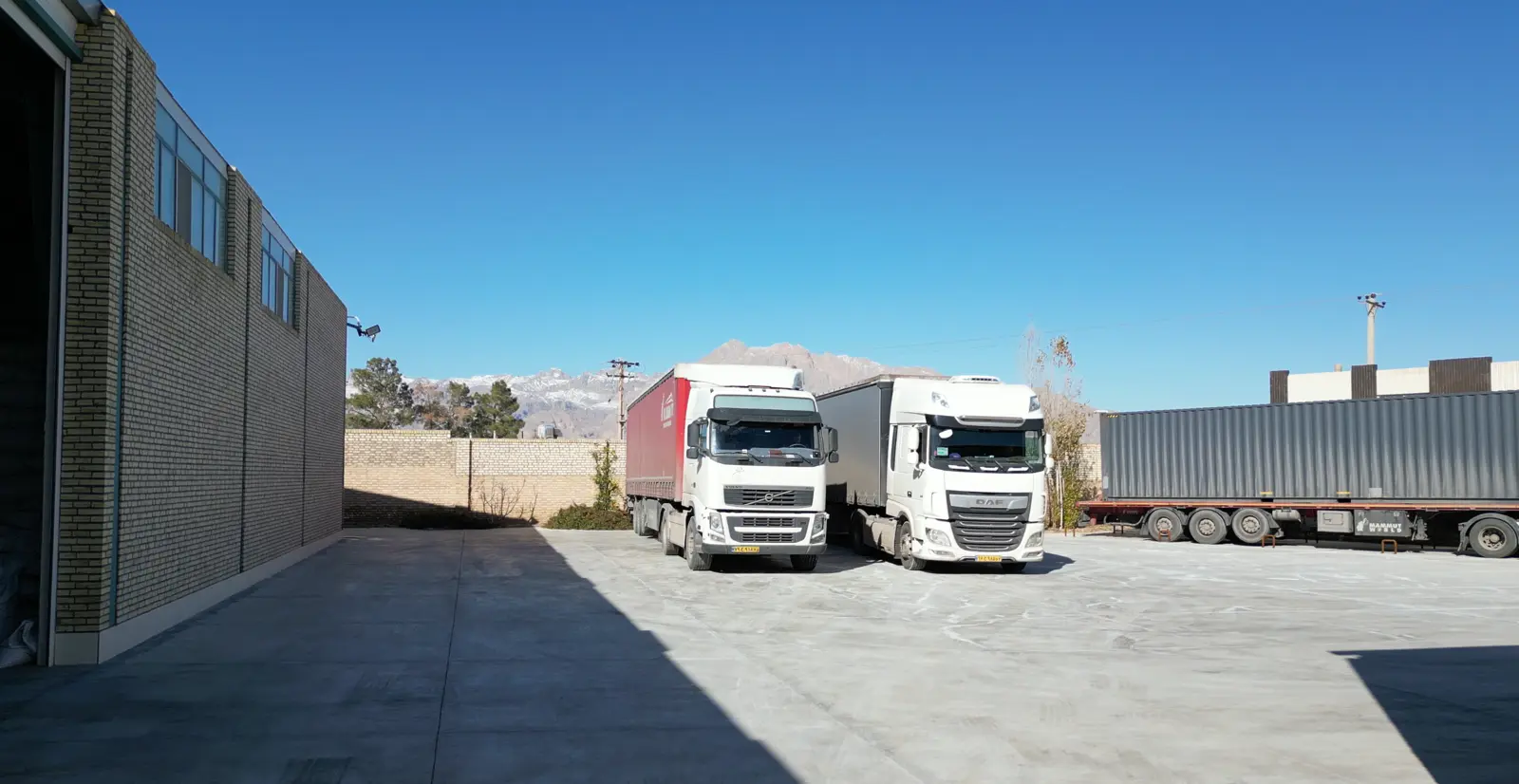 Two export trucks parked in the factory yard