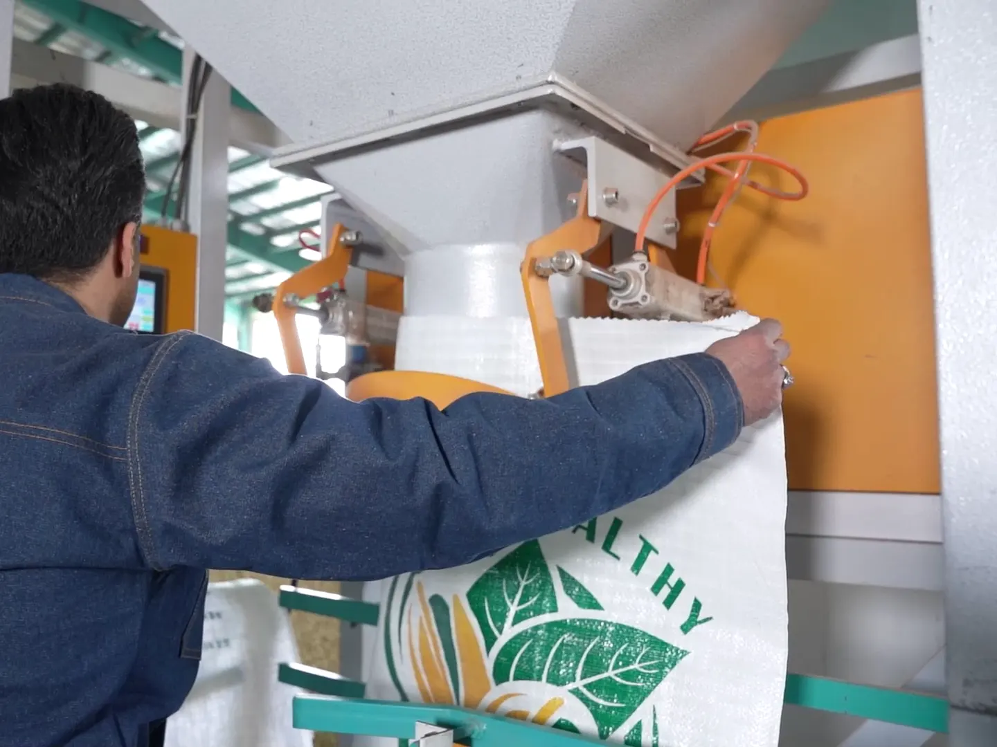 A worker attaching an export bag to the filling machine